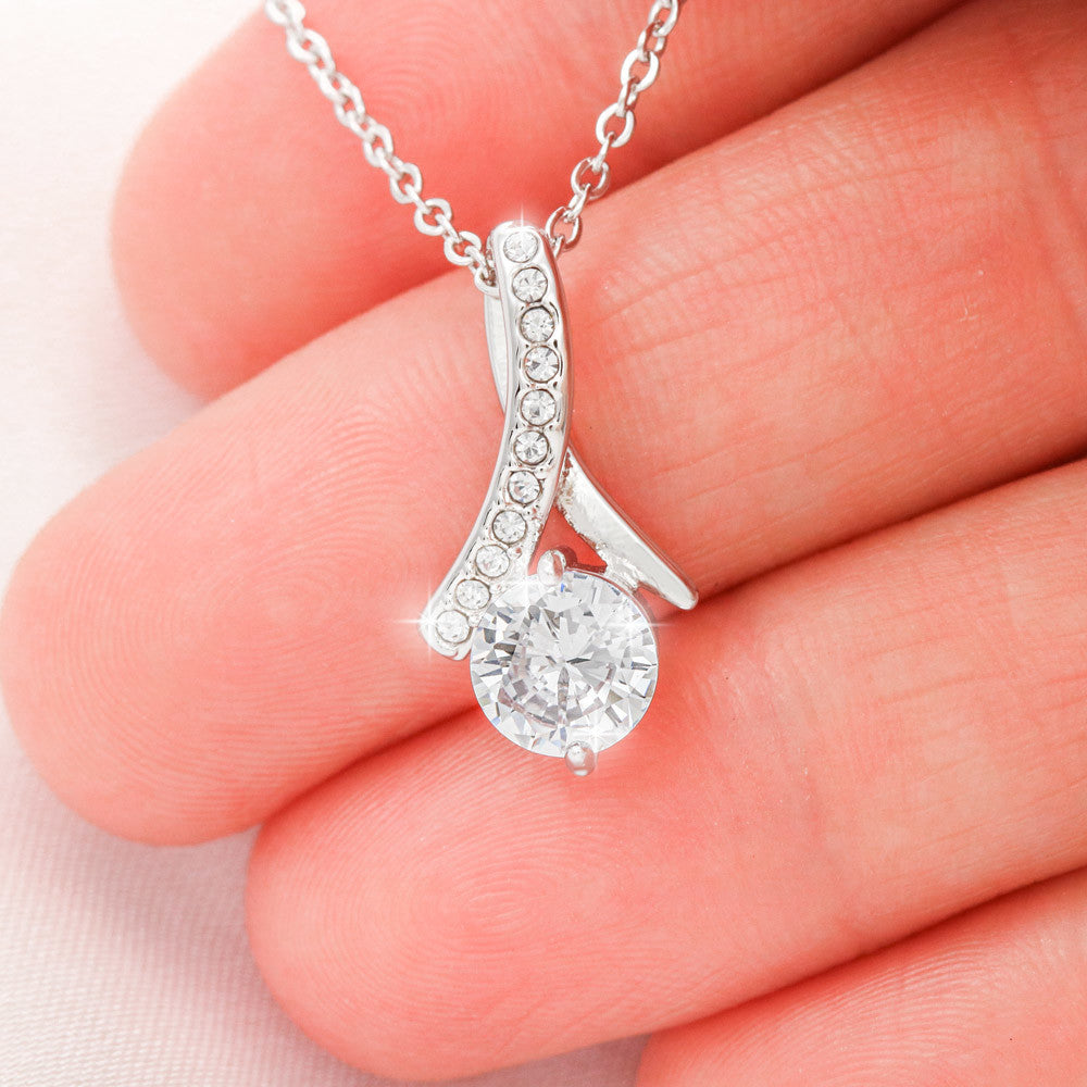 Alluring Beauty Petite Ribbon Shaped Pendant in 14k White Gold Finish or 18k Yellow Gold Finish over Stainless Steel with a 7mm Cubic Zirconia (No Message Card)