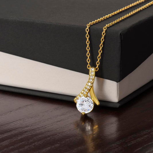 Alluring Beauty Petite Ribbon Shaped Pendant in 14k White Gold Finish or 18k Yellow Gold Finish over Stainless Steel with a 7mm Cubic Zirconia (No Message Card)